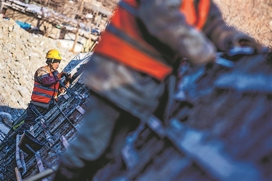 1月3日，房山區(qū)，工人正在雙泉河修筑堤壩。