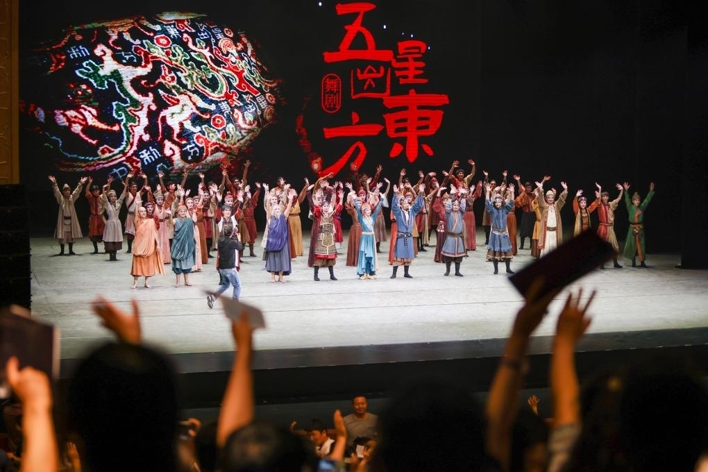 2023年7月31日，新疆和田地區(qū)新玉歌舞團在烏魯木齊京劇院演出舞劇《五星出東方》后和觀眾互相揮手致意。這場演出是第六屆中國新疆國際民族舞蹈節(jié)的參演劇目之一，曾榮獲國家“文華獎”等。新華社記者 郝昭 攝