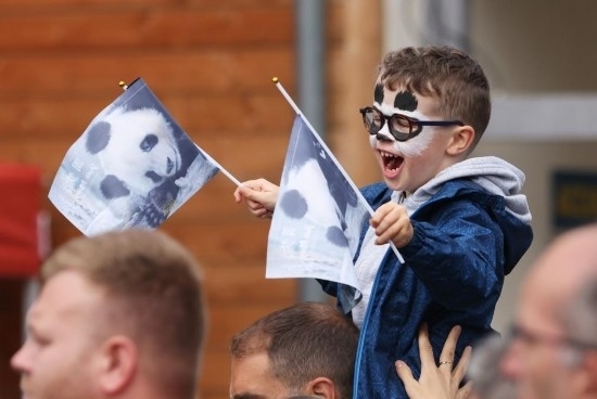  2023年7月26日，在法國(guó)圣艾尼昂市博瓦勒野生動(dòng)物園外，一名兒童等待送別熊貓“圓夢(mèng)”。新華社記者 高靜 攝