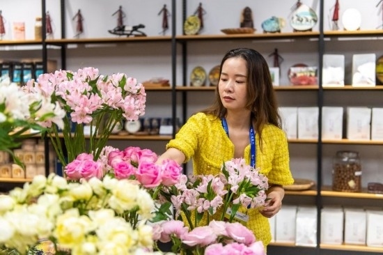 2023年7月1日，在位于湖南省長沙市的湖南高橋大市場，中非經(jīng)貿(mào)博覽會常設(shè)展館展區(qū)肯尼亞館工作人員在整理產(chǎn)自非洲的鮮花。新華社記者 陳思汗 攝