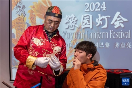 1月28日，在上海豫園舉行的民俗活動上，美國馬斯卡廷中學學生在非遺傳承人的指導下吹糖偶。 新華社記者 王翔 攝