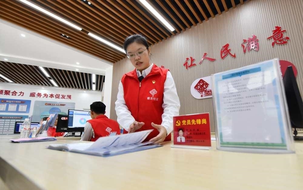 △2023年12月14日，廣西南寧市蟠龍社區(qū)，工作人員在為居民服務(wù)。