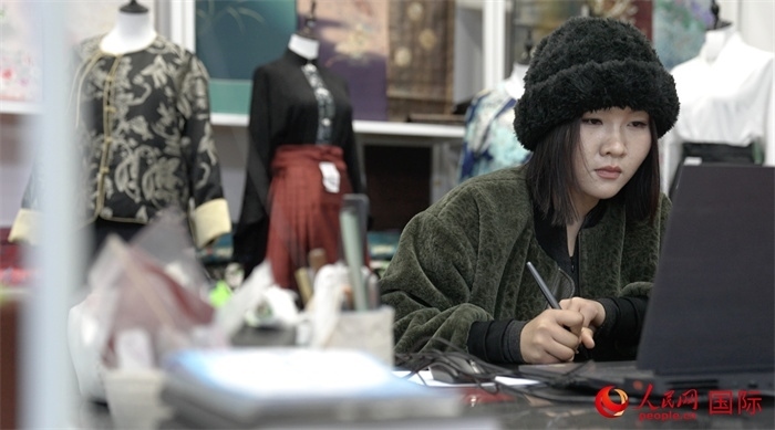 1月23日，在山東省菏澤市曹縣有愛云倉直播基地，張子晨正在設(shè)計漢服。 人民網(wǎng)記者 袁蒙攝