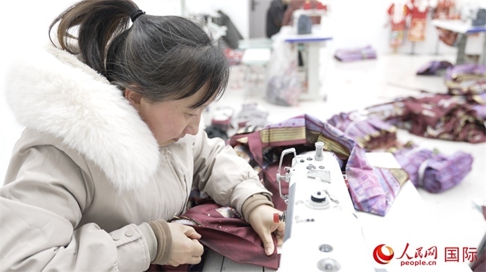1月24日，在山東省菏澤市曹縣大集鎮(zhèn)云牧服飾有限公司，高燕正在縫制馬面裙。 人民網(wǎng)記者 袁蒙攝