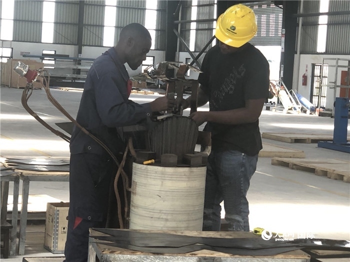 經(jīng)貿(mào)合作區(qū)廠房內(nèi)，當?shù)毓と苏诰o張作業(yè)。人民網(wǎng)記者 黃培昭攝