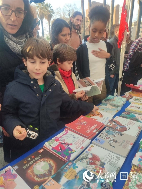 印刷精美的中國傳統(tǒng)文化叢書吸引了小游客的注意。人民網(wǎng)記者鄭彬攝