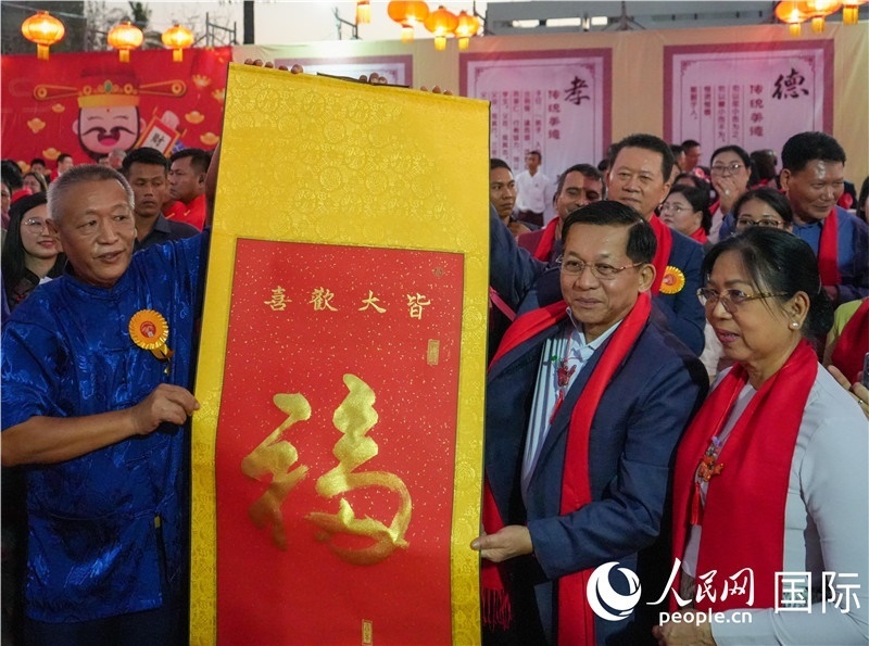 敏昂萊主席夫婦在“錦繡唐人街”新春慶典活動現(xiàn)場體驗中國傳統(tǒng)書法藝術-人民網記者謝佳君攝