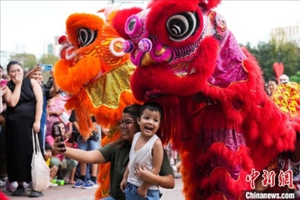 圖為舞獅表演吸引民眾合影。張興龍攝