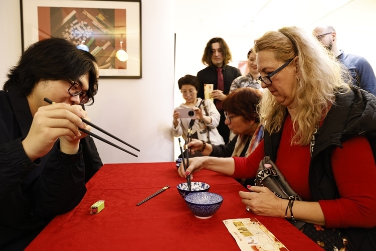 羅馬尼亞觀眾體驗用筷子夾花生。中國文化中心供圖