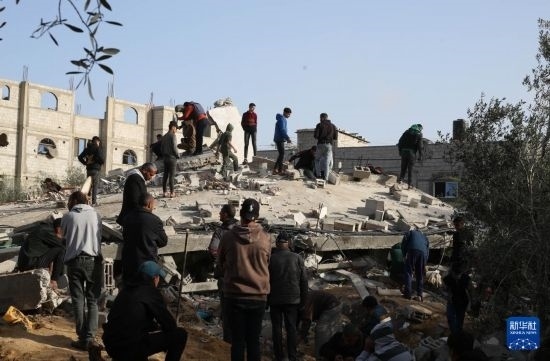  3月3日，在加沙地帶南部城市拉法，人們查看被以軍空襲破壞的建筑。新華社發(fā)（哈立德·奧馬爾攝）