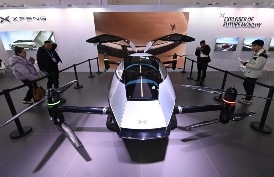 2023年12月1日，在鏈博會智能汽車鏈展區(qū)小鵬汽車展臺，參觀者觀看一臺智能飛行器。新華社記者蔡湘鑫攝