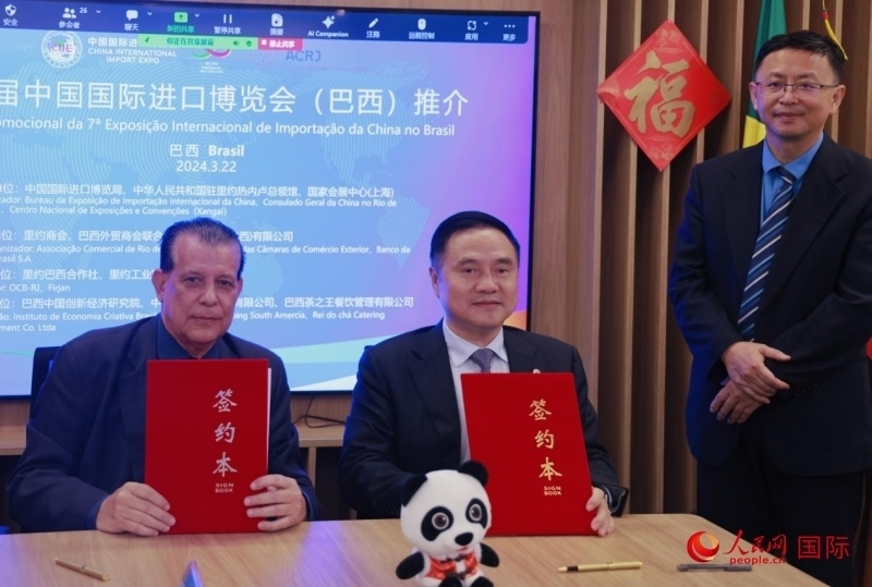 巴西外貿(mào)商會(huì)聯(lián)合會(huì)會(huì)長阿代爾·羅伯托（左）與中國國際進(jìn)口博覽局副局長吳政平（中）現(xiàn)場(chǎng)簽訂協(xié)議。人民網(wǎng)記者 宋亦然攝