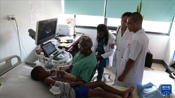 3月4日，在多米尼克羅索的中多友誼醫(yī)院，援多醫(yī)療隊(duì)成員、南方醫(yī)科大學(xué)第五附屬醫(yī)院心血管內(nèi)科主治醫(yī)師駱志鵬與當(dāng)?shù)蒯t(yī)生共同診療。新華社記者 王朝 攝