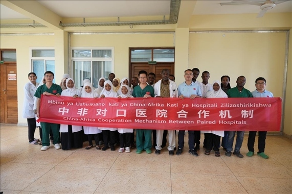 醫(yī)療隊隊員和當?shù)蒯t(yī)生們合影。中國援桑醫(yī)療隊供圖