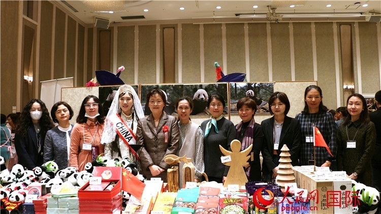 中國駐日本大使吳江浩夫人丁玥（左五）與使館人員在展位前合影留念。人民網(wǎng) 許可攝