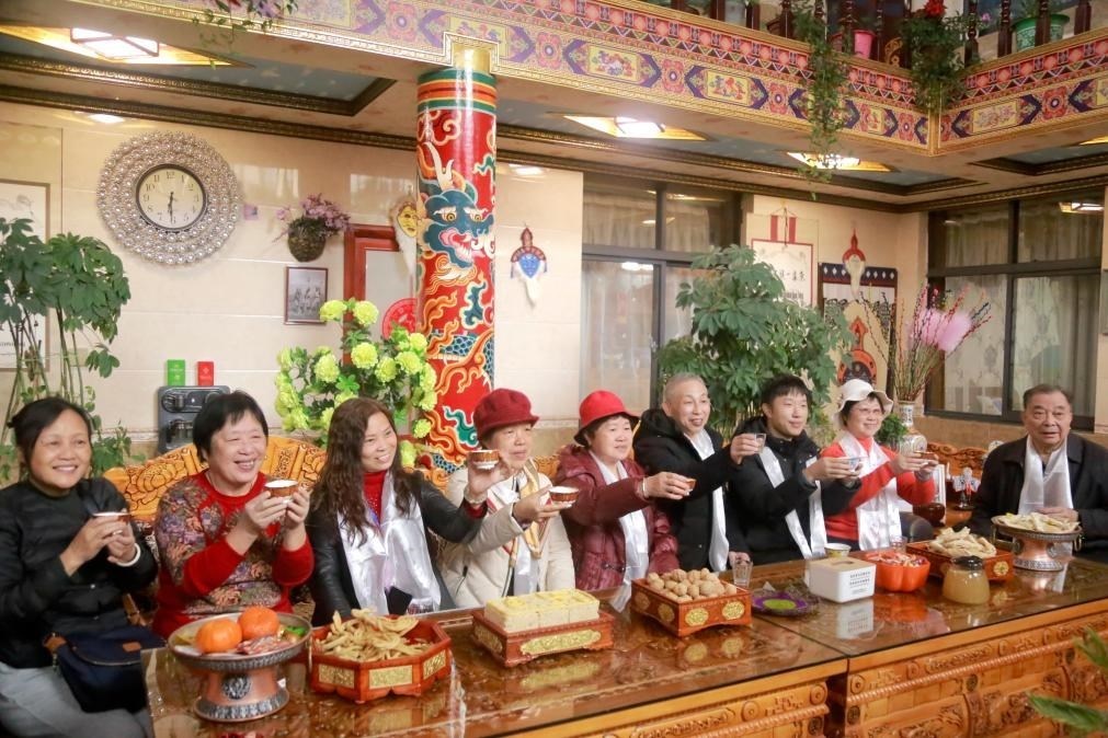 游客們?nèi)胱∶袼藓?，舉杯共飲酥油茶。新華社記者 邱星翔 攝