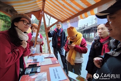 1月6日，“2024成都蒲江柑甜采摘節(jié)”上，記者見到了小萌（左一）和許多年輕人忙著做訪客接待、現(xiàn)場布置、票務(wù)核對、采摘服務(wù)等工作。人民網(wǎng)記者朱虹攝