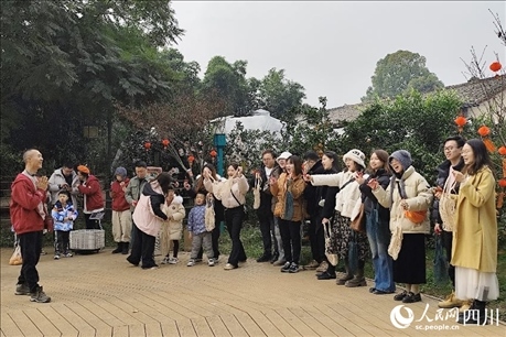 葉科（左一）給前來參與活動(dòng)的“柑爸柑媽”介紹生態(tài)種植果。人民網(wǎng)記者朱虹攝