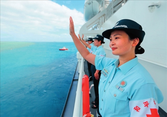 中國(guó)海軍“和平方舟”號(hào)醫(yī)院船結(jié)束訪問(wèn)湯加時(shí)，任務(wù)官兵中的文職人員向歡送人群揮手告別（2023年8月4日攝）。徐巍攝/本刊