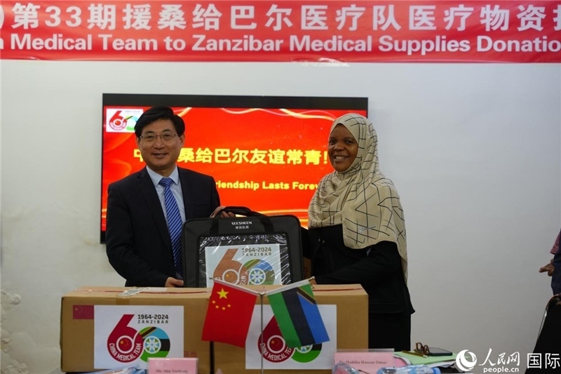 江蘇省蘇北人民醫(yī)院黨委書記束余聲捐贈物資與桑衛(wèi)生部首席秘書哈比巴。中國援桑醫(yī)療隊(duì)供圖