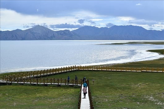 △ 游客行走在青?，敹嗫h冬格措納湖畔的木棧道上。