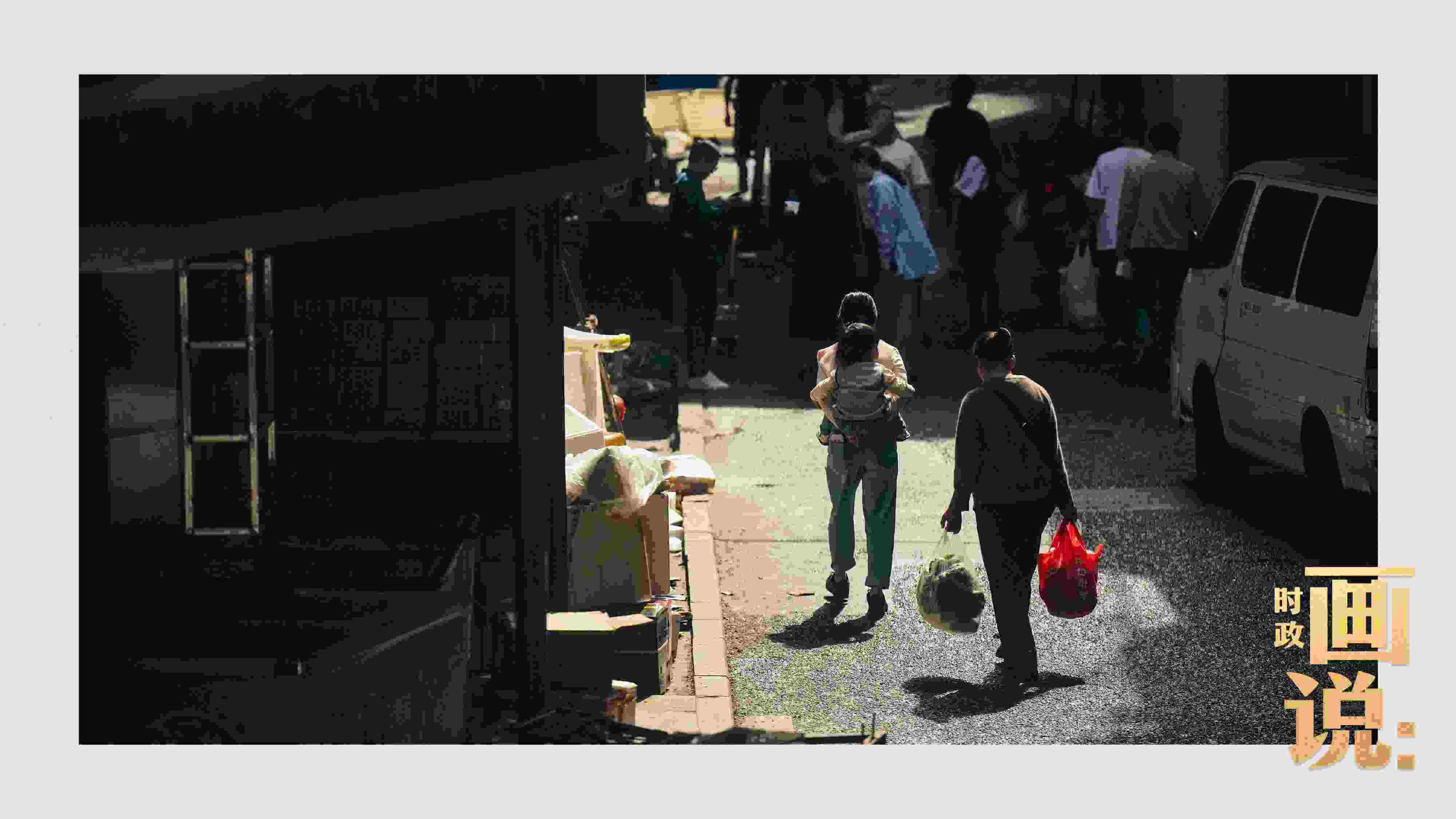 △老城區(qū)鱗次的樓宇間漏下一縷光，路人走過(guò)暖陽(yáng)。