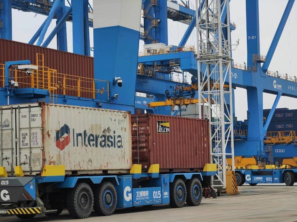 在欽州自動(dòng)化集裝箱碼頭，智能導(dǎo)引運(yùn)輸車在運(yùn)送集裝箱。新華社記者趙歡 攝