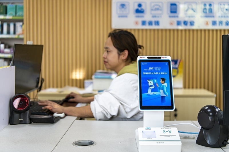 2024年4月10日，浙江金華市區(qū)一家民眾大藥房柜臺(tái)上設(shè)置著醫(yī)?！八⒛樦Ц丁睓C(jī)器，群眾看病更加便利。