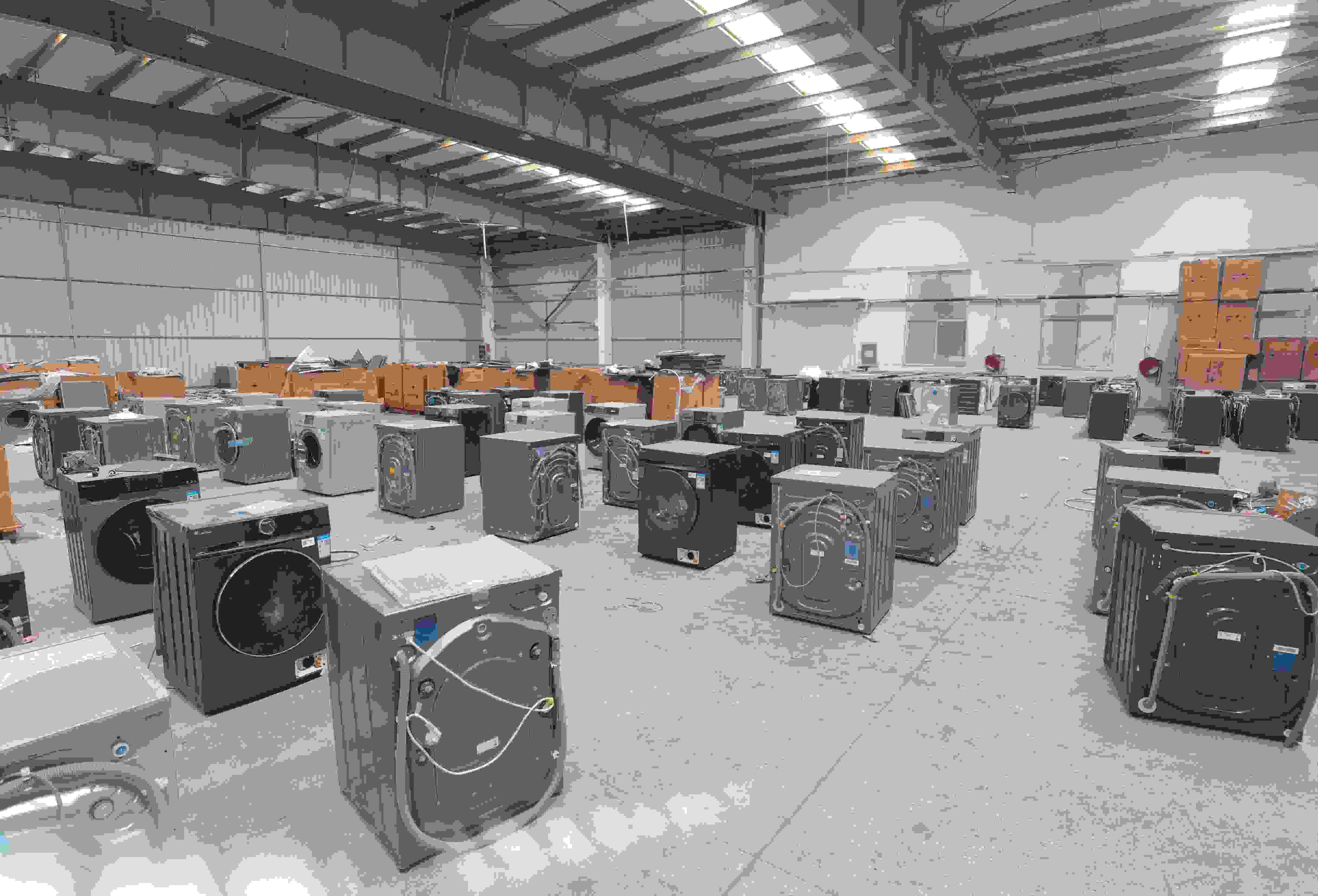 專(zhuān)案組民警查扣涉案場(chǎng)所及假冒知名品牌洗衣機(jī)。巨野警方供圖