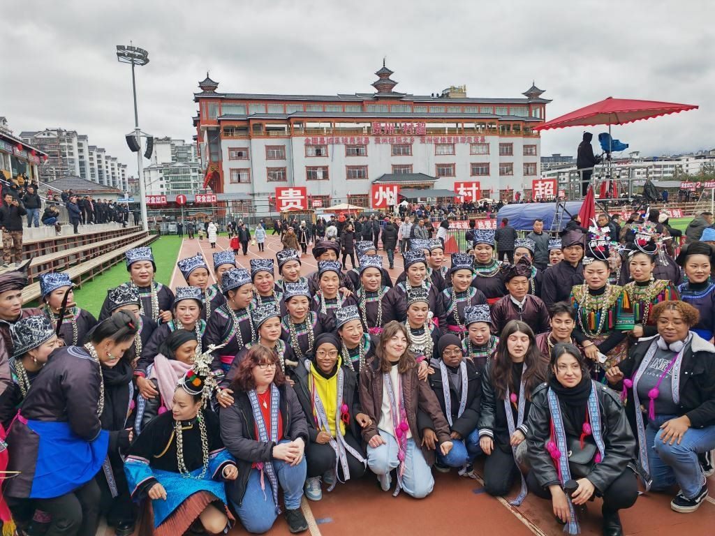 法國青年在“村超”賽場邊與參加表演的村民合影。新華社記者 羅羽 攝