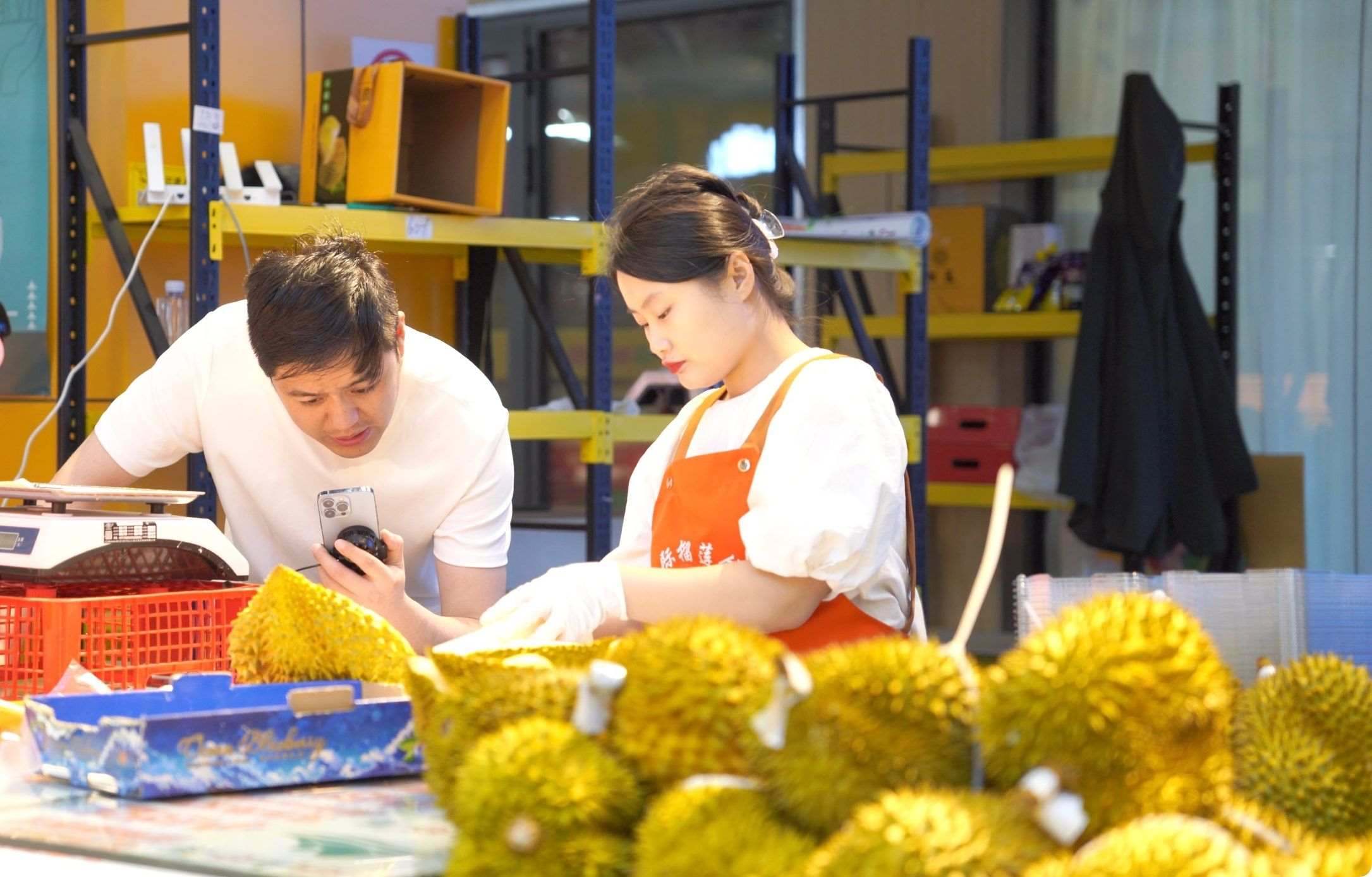 榴蓮商家正在通過(guò)手機(jī)直播銷售榴蓮。人民網(wǎng)記者申佳平 攝