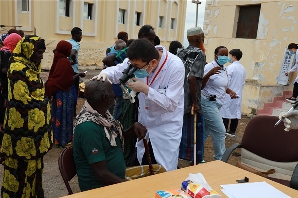 在義診現(xiàn)場(chǎng)，中國(guó)醫(yī)生與當(dāng)?shù)鼐用窈嫌傲裟?，吉布提鹽業(yè)投資公司供圖