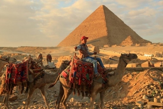 1月24日，商販騎駱駝離開埃及吉薩金字塔景區(qū)。新華社記者 隋先凱 攝
