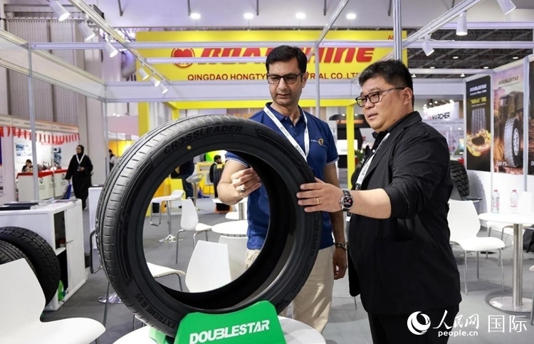 工作人員向客戶展示雙星電動(dòng)汽車輪胎。和傳統(tǒng)汽車輪胎相比，電動(dòng)汽車輪胎具有更高承載能力、更加靜音舒適、更好極速抓地、更低滾動(dòng)阻力等特點(diǎn)。人民網(wǎng)記者 管克江攝