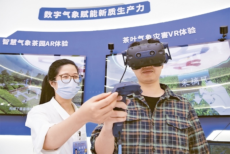 2024年5月23日，第七屆數(shù)字中國建設(shè)峰會(huì)現(xiàn)場(chǎng)體驗(yàn)區(qū)在福州海峽國際會(huì)展中心向?qū)I(yè)觀眾開放。本次現(xiàn)場(chǎng)體驗(yàn)區(qū)圍繞本屆峰會(huì)主題“釋放數(shù)據(jù)要素價(jià)值，發(fā)展新質(zhì)生產(chǎn)力”，設(shè)置“數(shù)字惠民”、“數(shù)字能力”、“數(shù)字基礎(chǔ)”、“數(shù)字生態(tài)”、“數(shù)字賦能”五大板塊。圖為一名觀眾（右）在數(shù)字氣象賦能新質(zhì)生產(chǎn)力展臺(tái)上進(jìn)行體驗(yàn)。 新華社記者 魏培全/攝