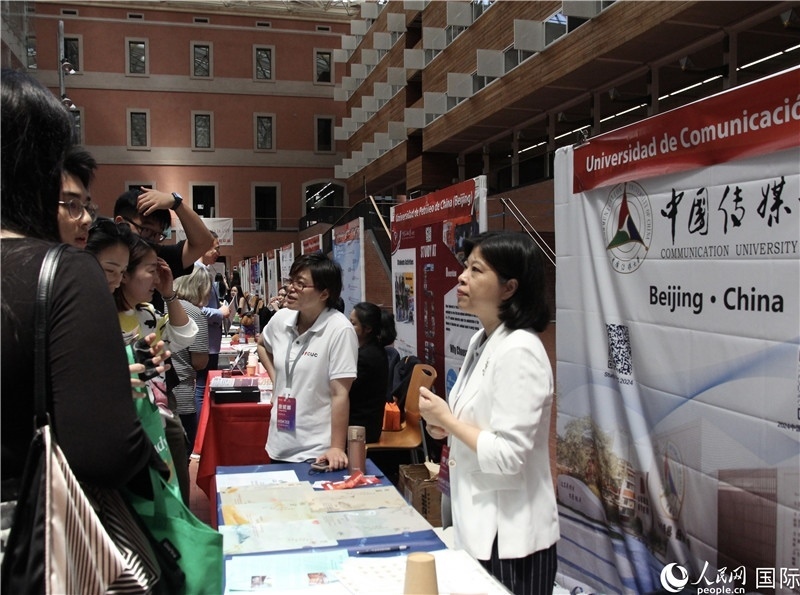 旅西華人華僑在展臺前咨詢。人民網(wǎng)記者 許海林?jǐn)z