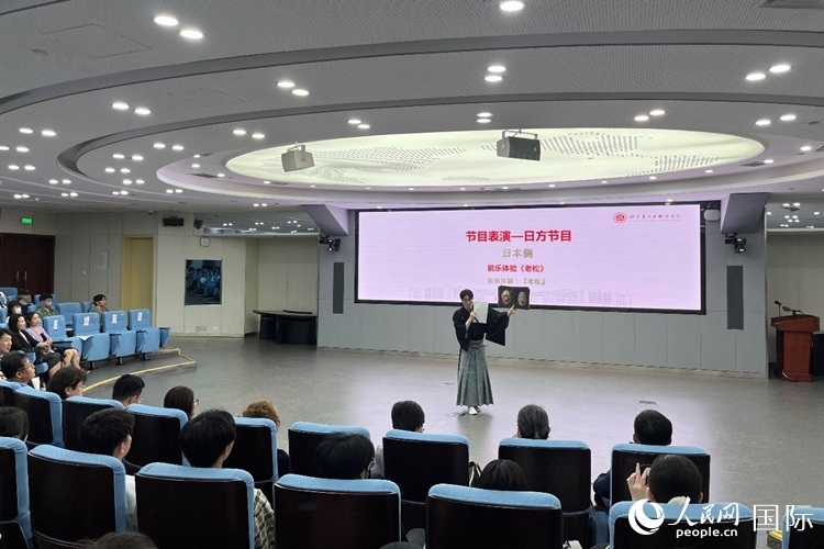 日本大學(xué)生介紹能樂知識。人民網(wǎng)記者 陳思攝