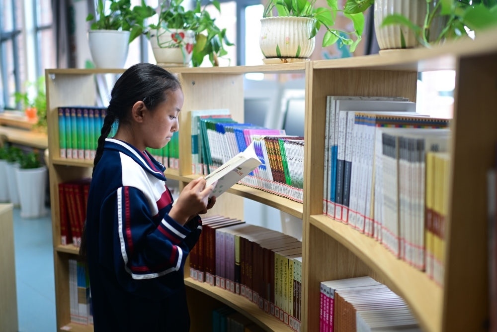 6月18日，果洛西寧民族中學(xué)學(xué)生尼東拉毛在圖書室看書。