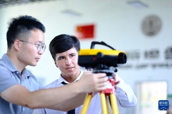 6月14日，在塔吉克斯坦首都杜尚別的魯班工坊，來自天津城市建設(shè)管理職業(yè)技術(shù)學(xué)院的老師（左）指導(dǎo)學(xué)生。新華社記者 鄭開君 攝