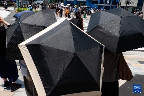 7月4日，人們?cè)谌毡緰|京原宿的街道上等待紅綠燈。新華社記者 張笑宇 攝