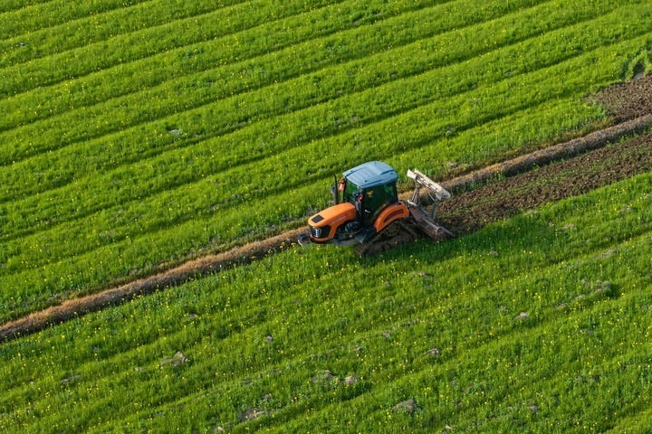 2024年3月19日，在湖南省常德市鼎城區(qū)謝家鋪鎮(zhèn)港中坪村，村民駕駛農(nóng)機(jī)翻耕田地（無人機(jī)照片）。新華社記者 陳思汗 攝