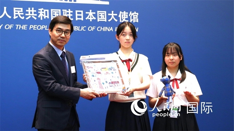 日本小大使向中國(guó)駐日本大使館臨時(shí)代辦施泳贈(zèng)送當(dāng)?shù)靥厣Y品。人民網(wǎng) 許可攝