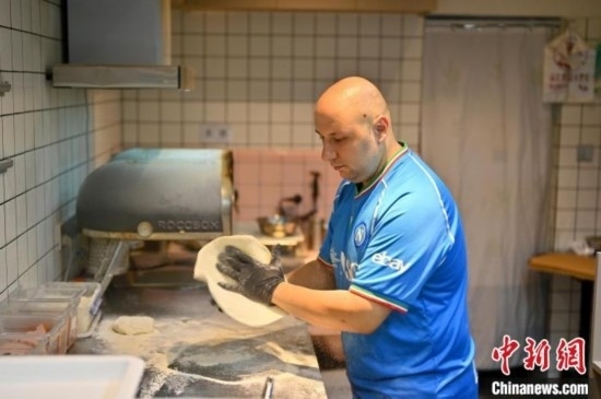 近日，韋榮耀在自家披薩小店內(nèi)忙活。俞靖 攝