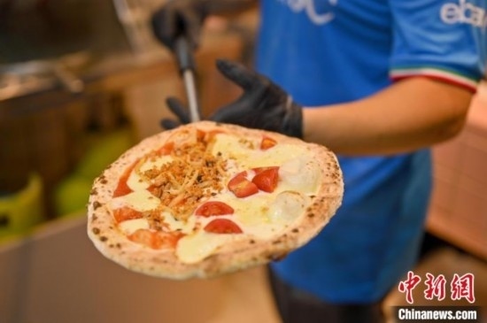 近日，韋榮耀展示他制作的“老友味”披薩。 俞靖 攝