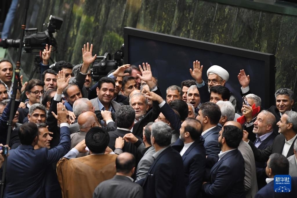 7月30日，在伊朗德黑蘭的伊朗議會(huì)，佩澤希齊揚(yáng)（中）離開(kāi)總統(tǒng)就職典禮現(xiàn)場(chǎng)時(shí)揮手致意。新華社記者 沙達(dá)提 攝