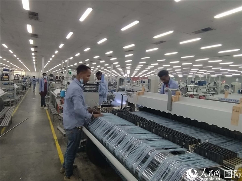 無錫金茂埃塞面料廠車間內(nèi)，當(dāng)?shù)毓と苏谝唤z不茍地作業(yè)。人民網(wǎng)記者 黃培昭攝