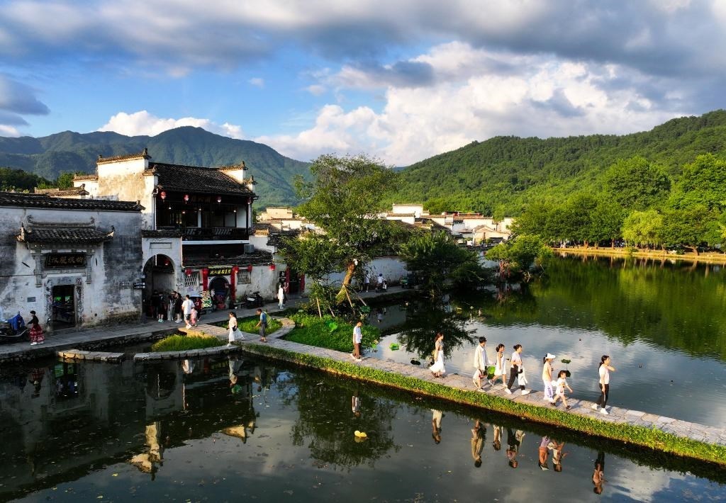 2024年7月7日，游客在安徽省黃山市黟縣宏村游玩。新華社記者杜宇攝