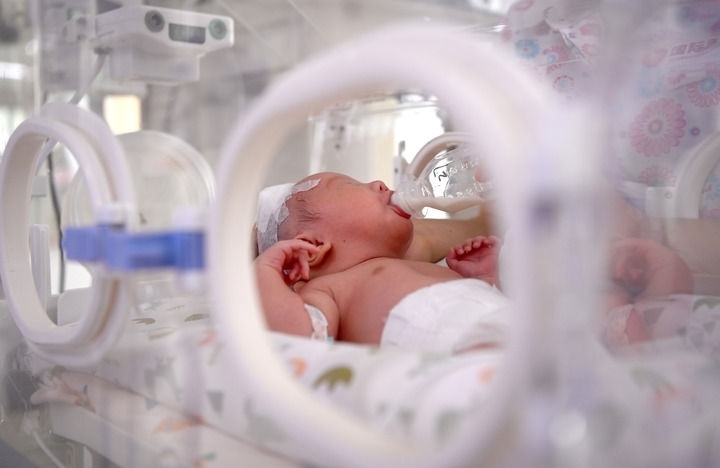 2024年6月1日，在西安國(guó)際醫(yī)學(xué)中心醫(yī)院新生兒科病房，護(hù)士為新生兒喂奶。 新華社記者 劉瀟 攝