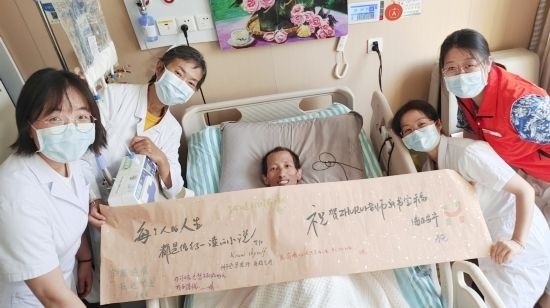 7月26日，海淀醫(yī)院安寧療護(hù)科醫(yī)護(hù)團(tuán)隊(duì)為朱銳送來(lái)一條寫滿祝福的橫幅。（受訪者供圖）