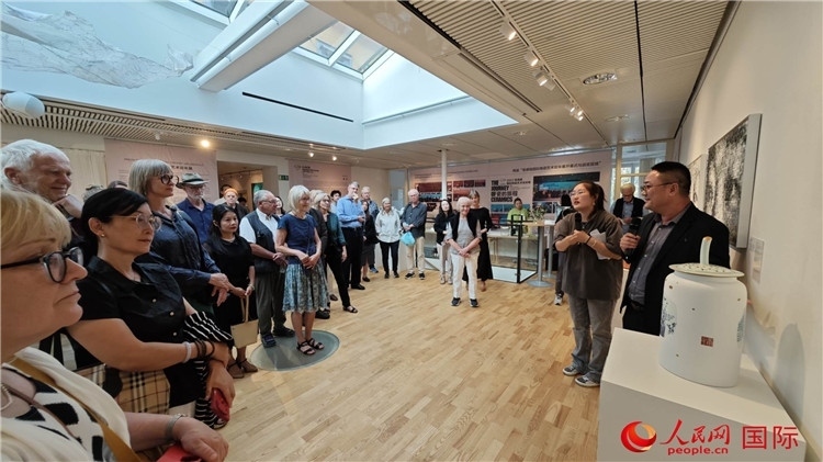 參展人、景德鎮(zhèn)陶瓷大學美術(shù)學院副院長邵長宗（右一）向來賓介紹參展作品。人民網(wǎng)記者 殷淼攝